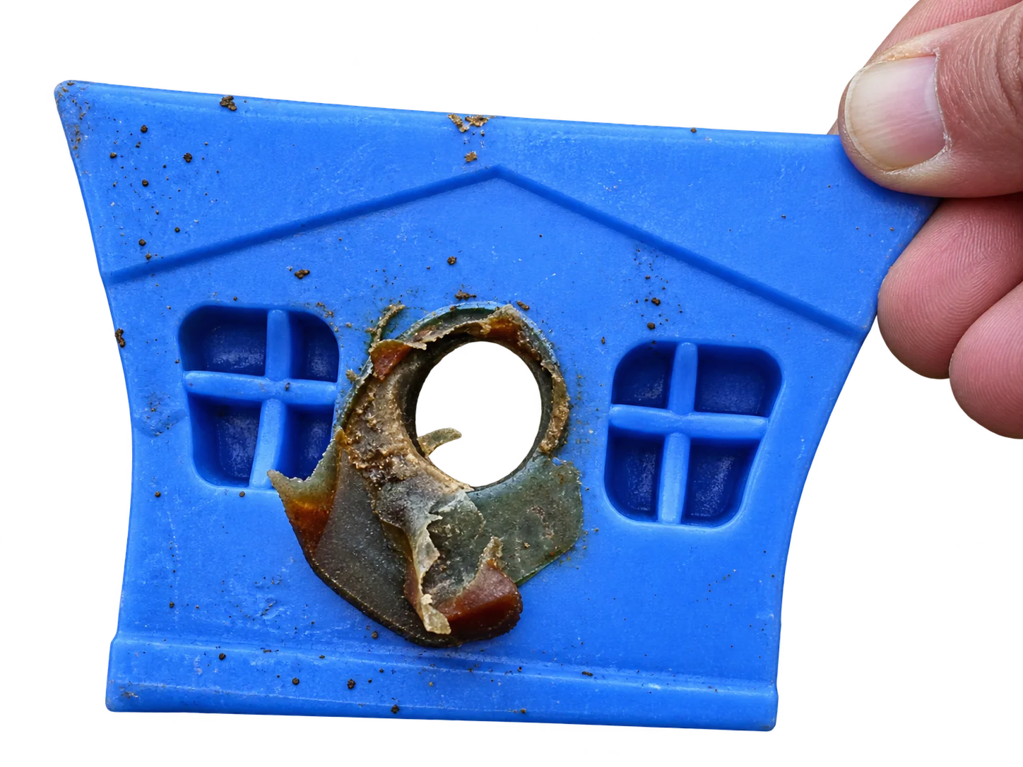 Objet bleu en forme de maison, percé d’un trou pour la main