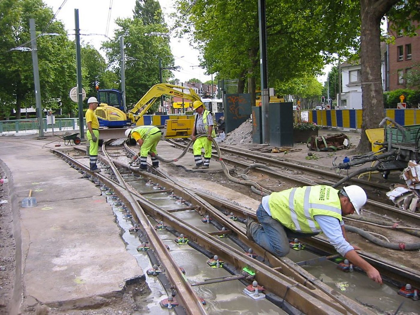 Ouvriers au travail sur la pose de rails de tramway en ville